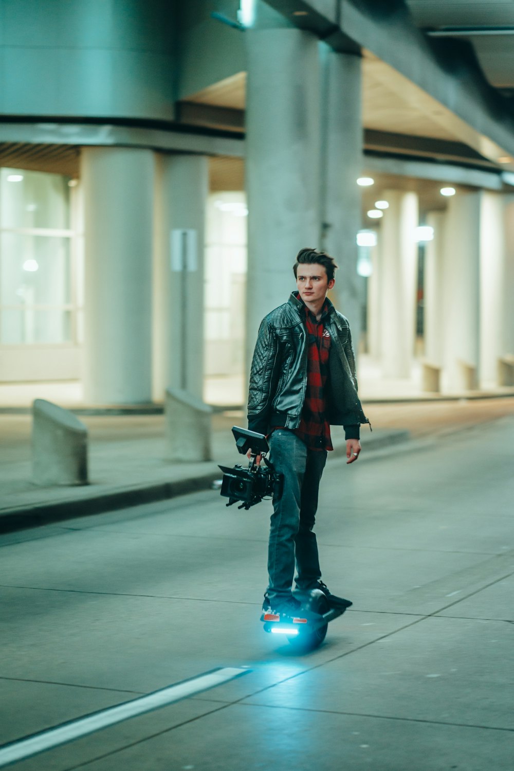 man in black coat and blue denim jeans walking on sidewalk