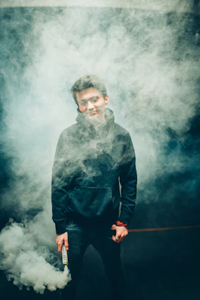 A sleek Shockfog device mounted near a doorway releasing thick white smoke that fills a modern indoor space.