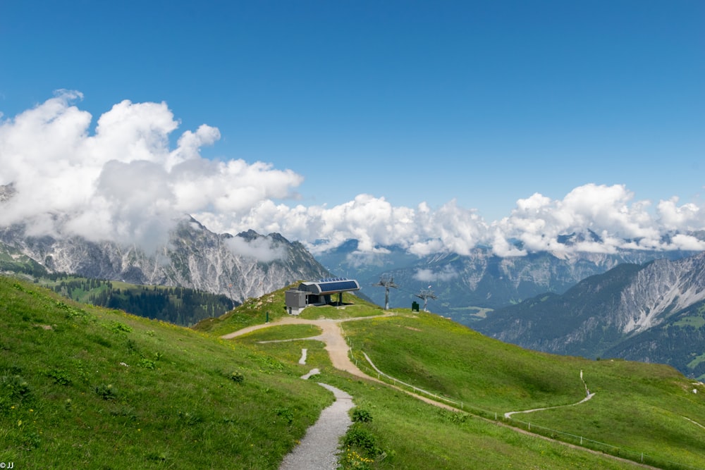 white and black house on green grass field near mountain under blue sky during daytime