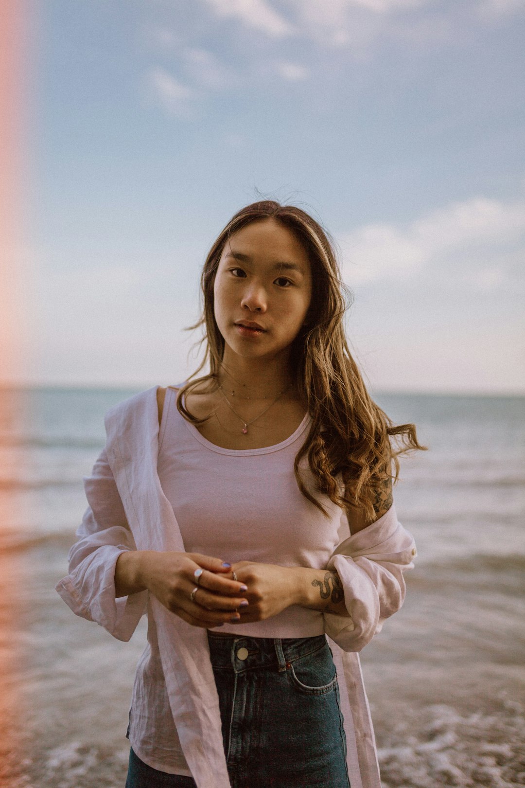 woman in white long sleeve shirt standing on beach during daytime