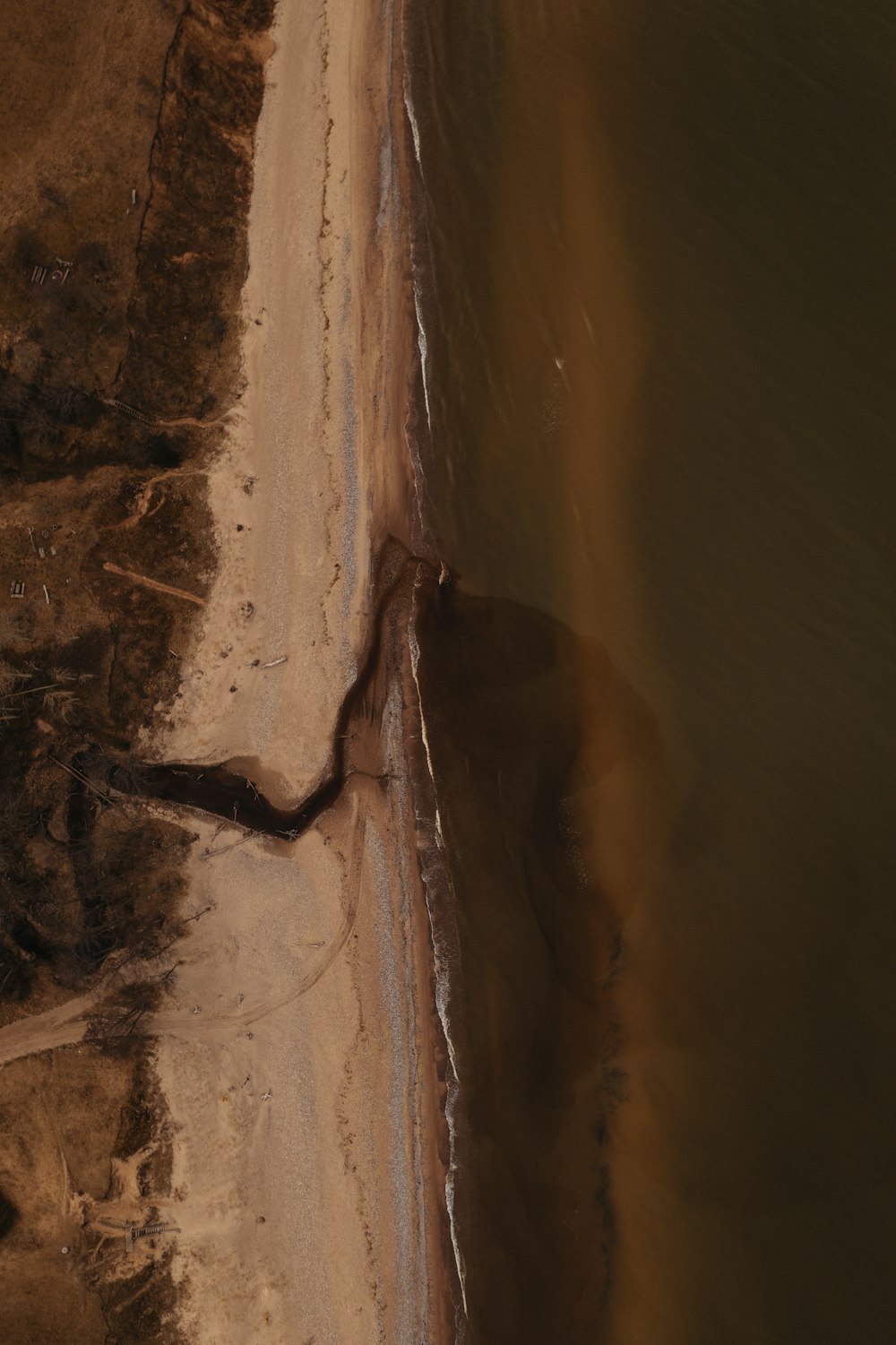 brown sand near body of water during daytime