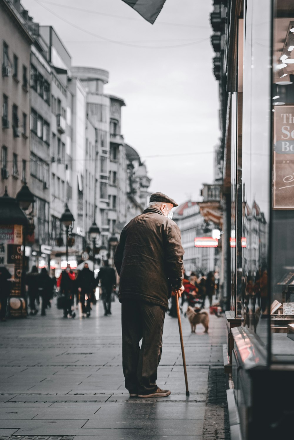 man in black jacket and black pants walking on sidewalk during daytime