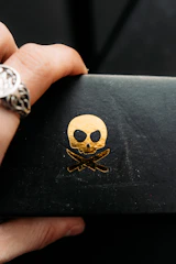 Close-up of a skull emblem with flames in red and gold on a leather jacket.