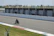 A motorcyclist on a racetrack being filmed for video analysis during training.