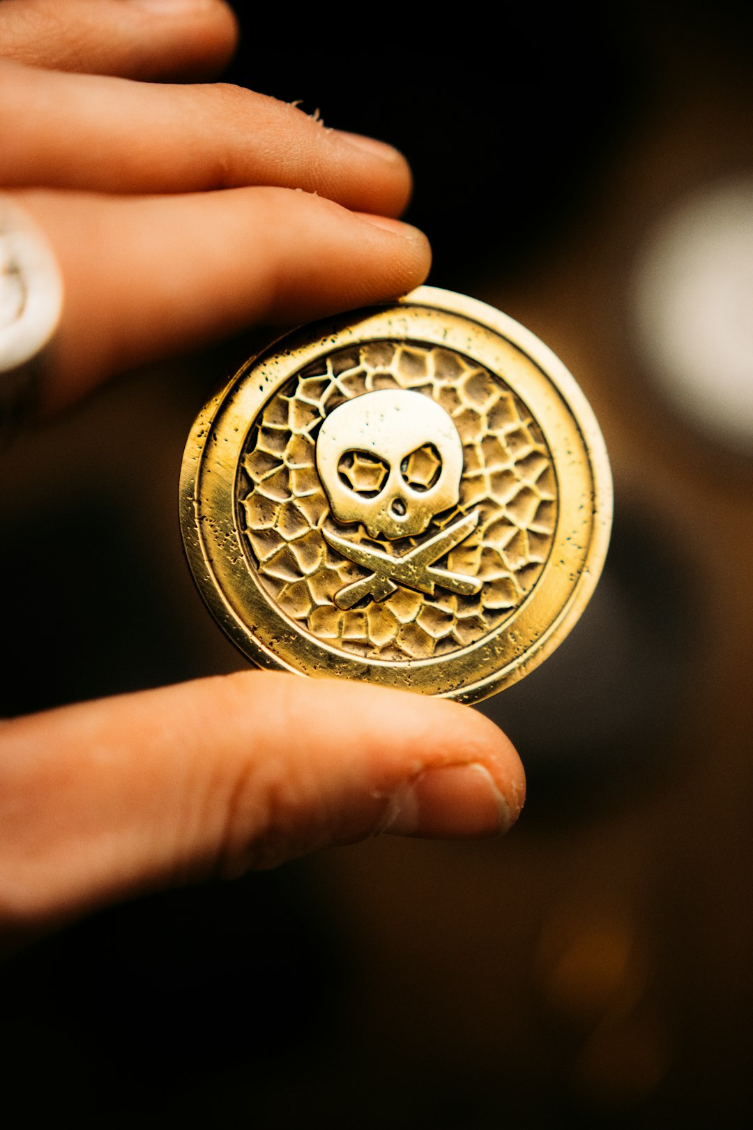 gold round coin in persons hand