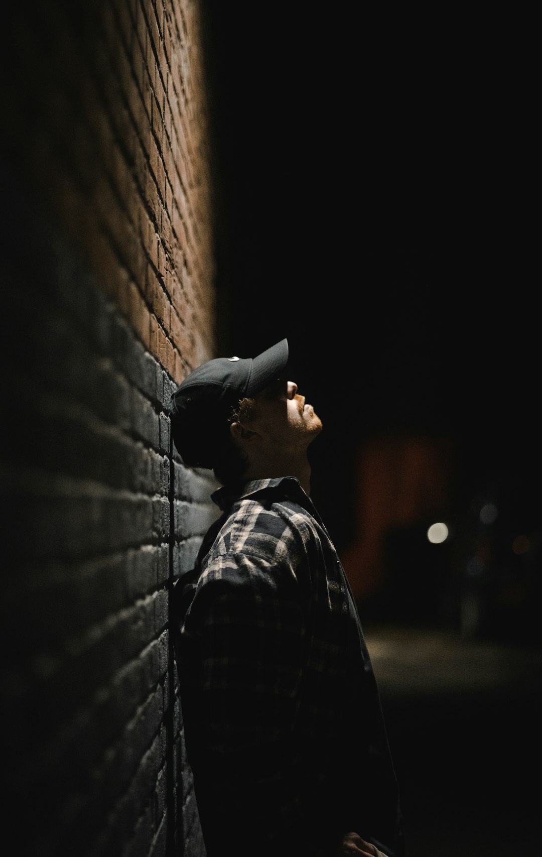 man in black and gray plaid dress shirt wearing black cap