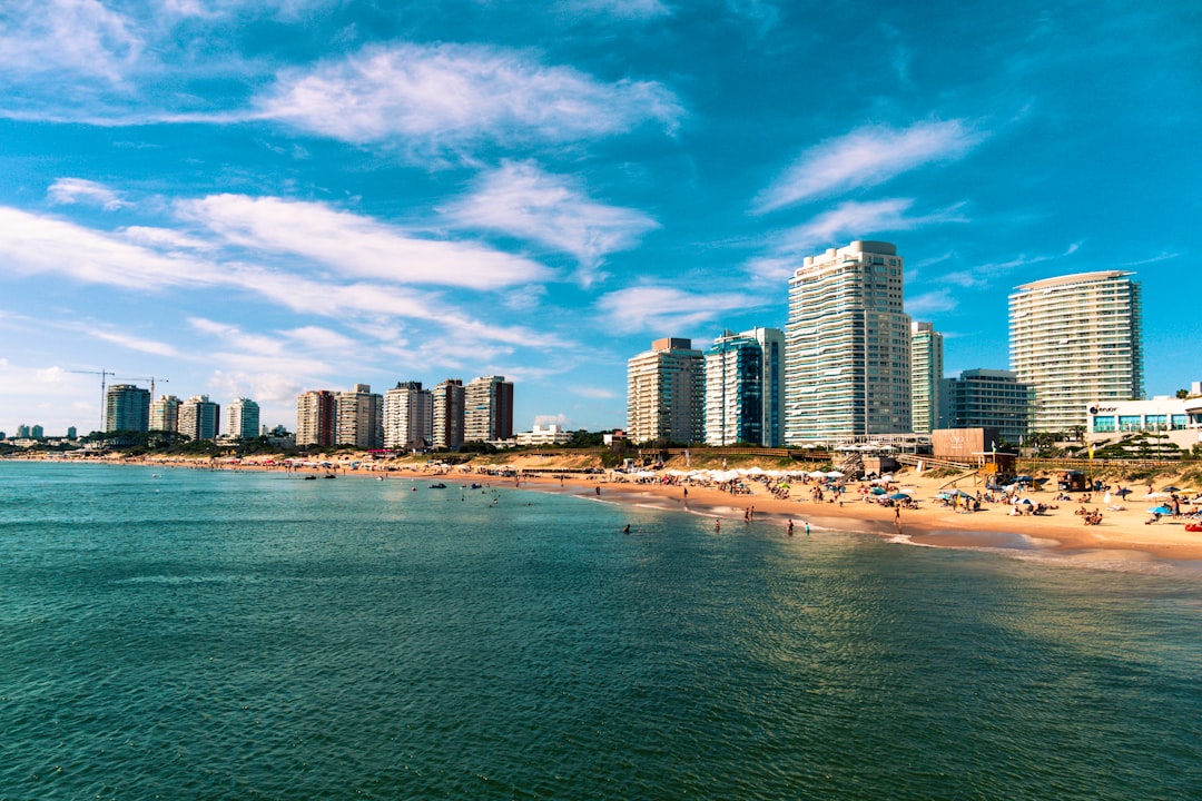 high rise buildings near sea under blue sky and white clouds during daytime