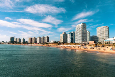 high rise buildings near sea under blue sky and white clouds during daytime