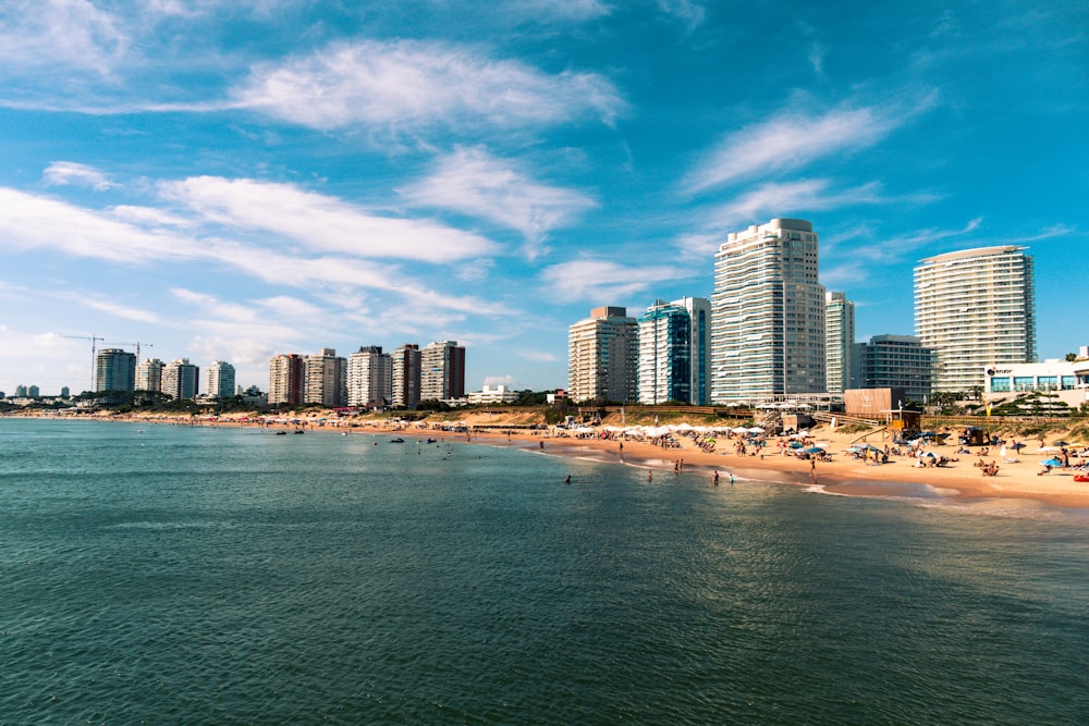 edificios de gran altura cerca del mar bajo el cielo azul y las nubes blancas durante el día