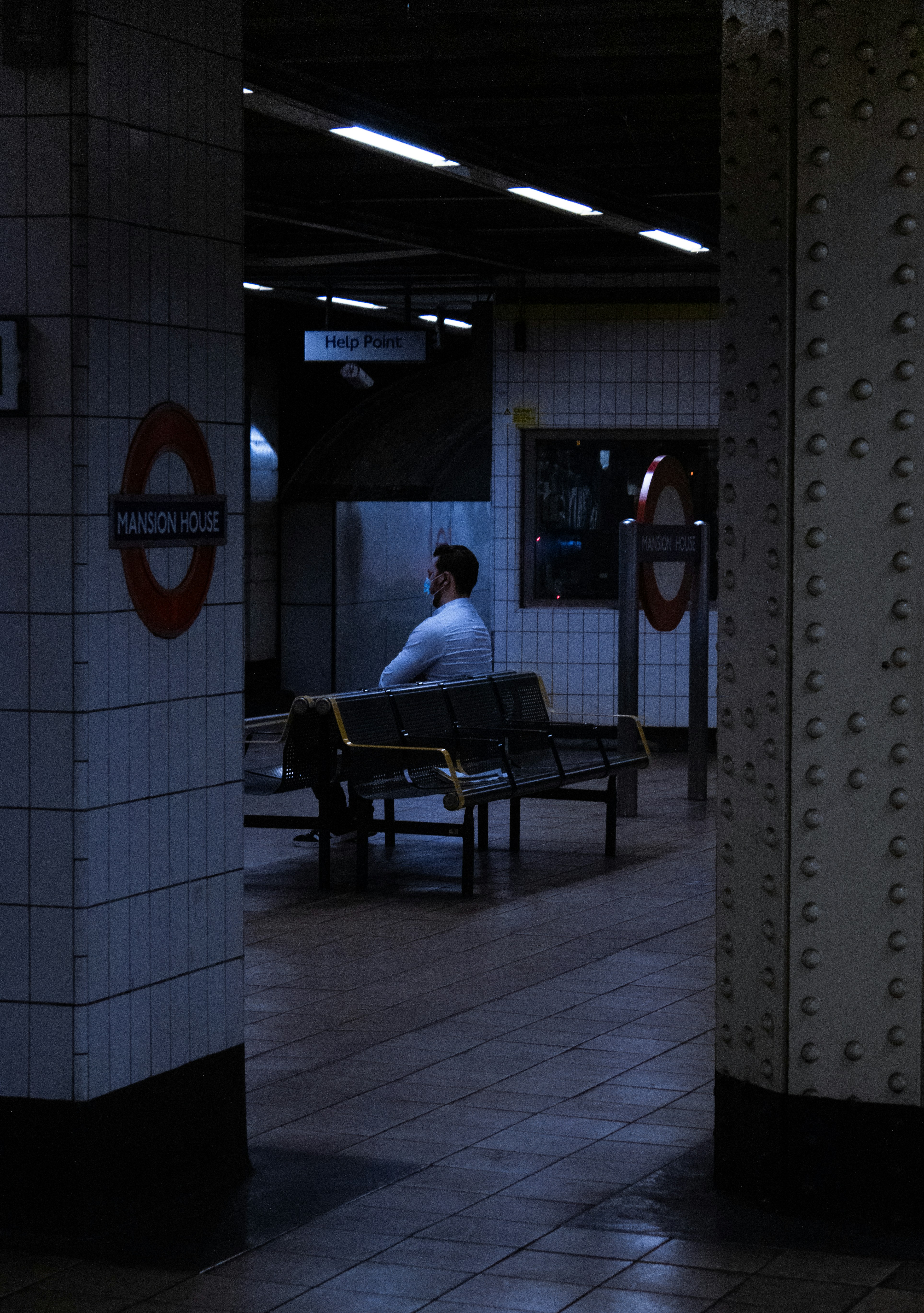 man in white shirt sitting on black bench