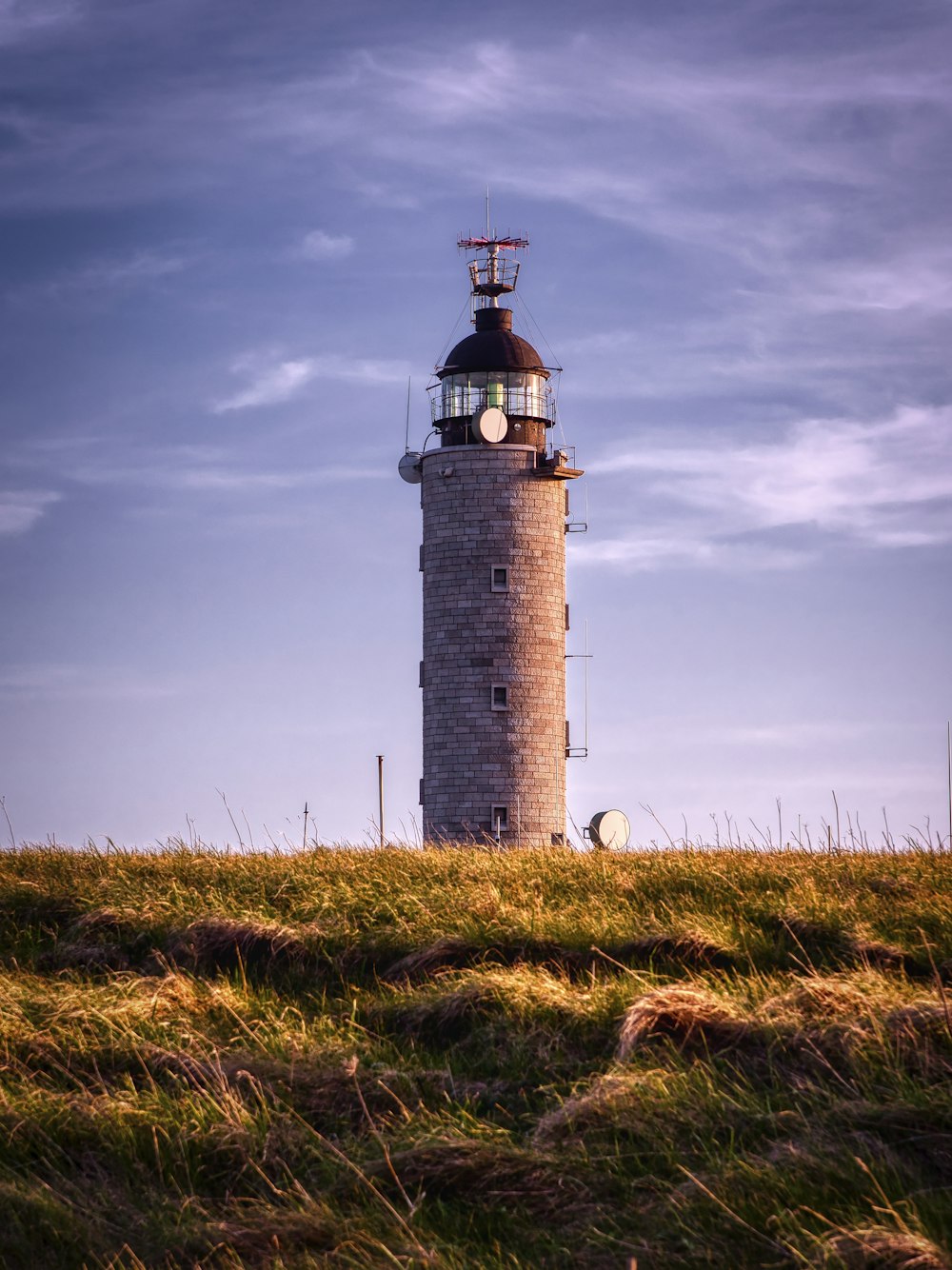 brown and white lighthouse under cloudy sky during daytime