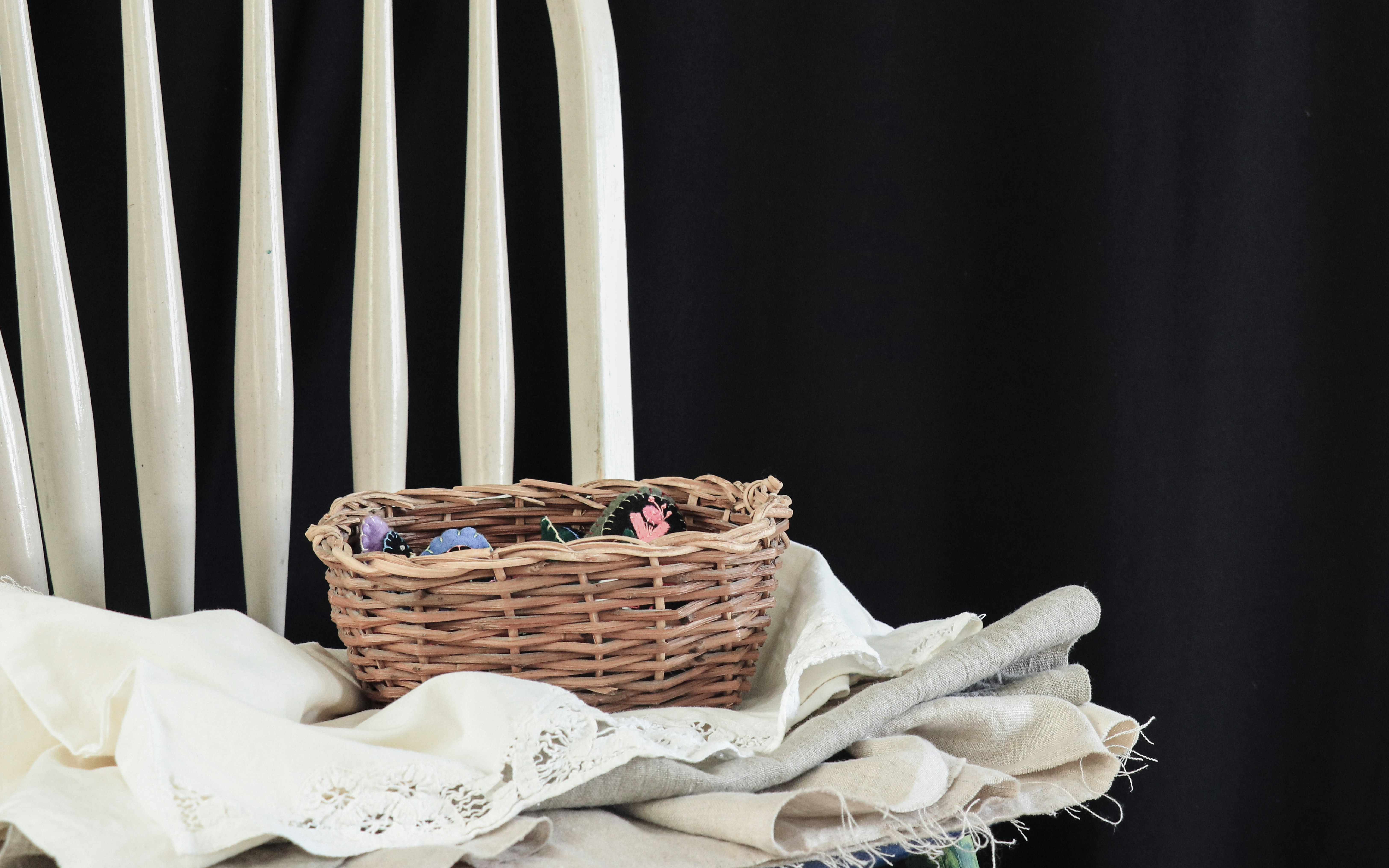 brown woven basket on white textile