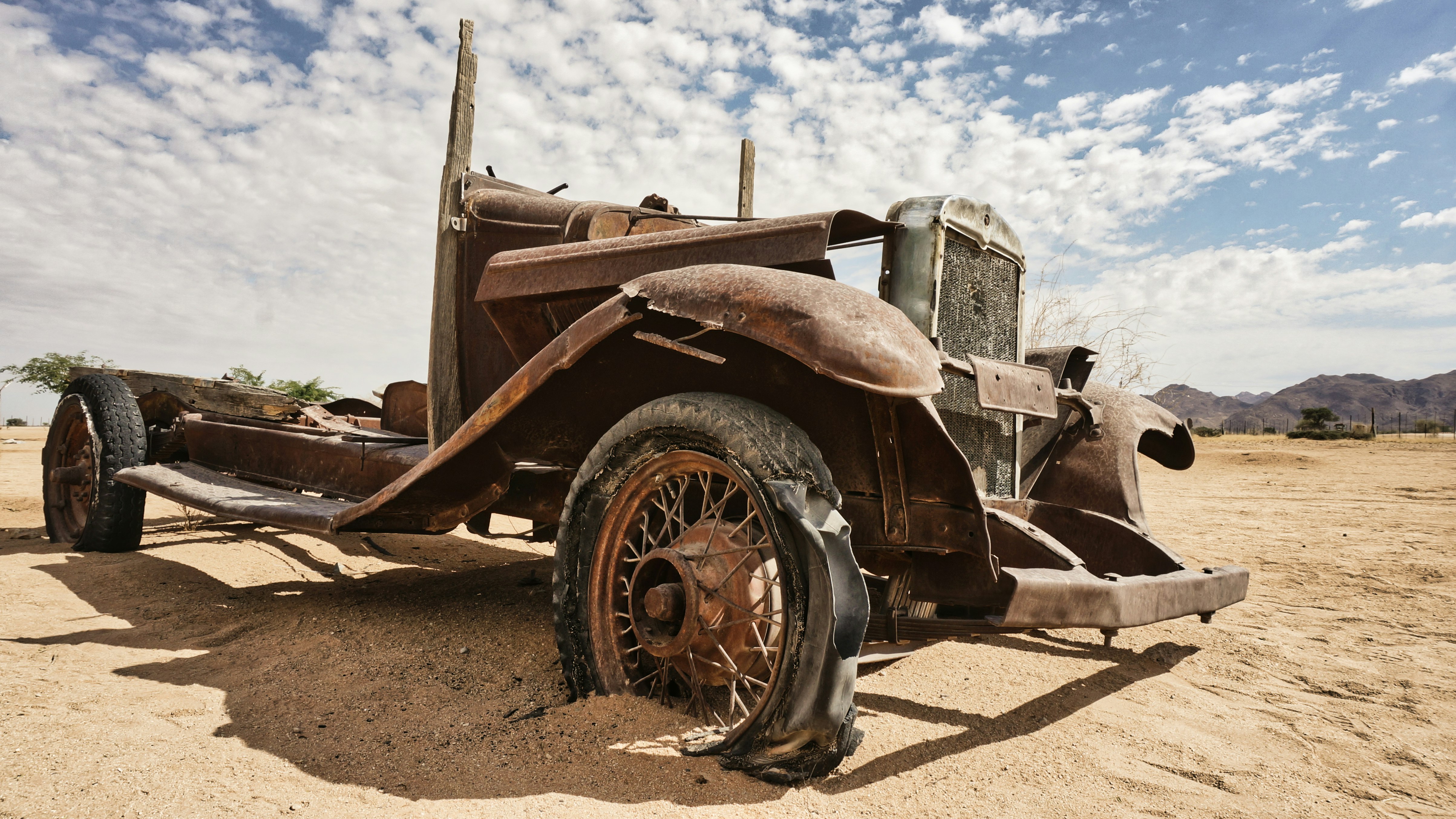 brown and black vintage car on brown sand during daytime