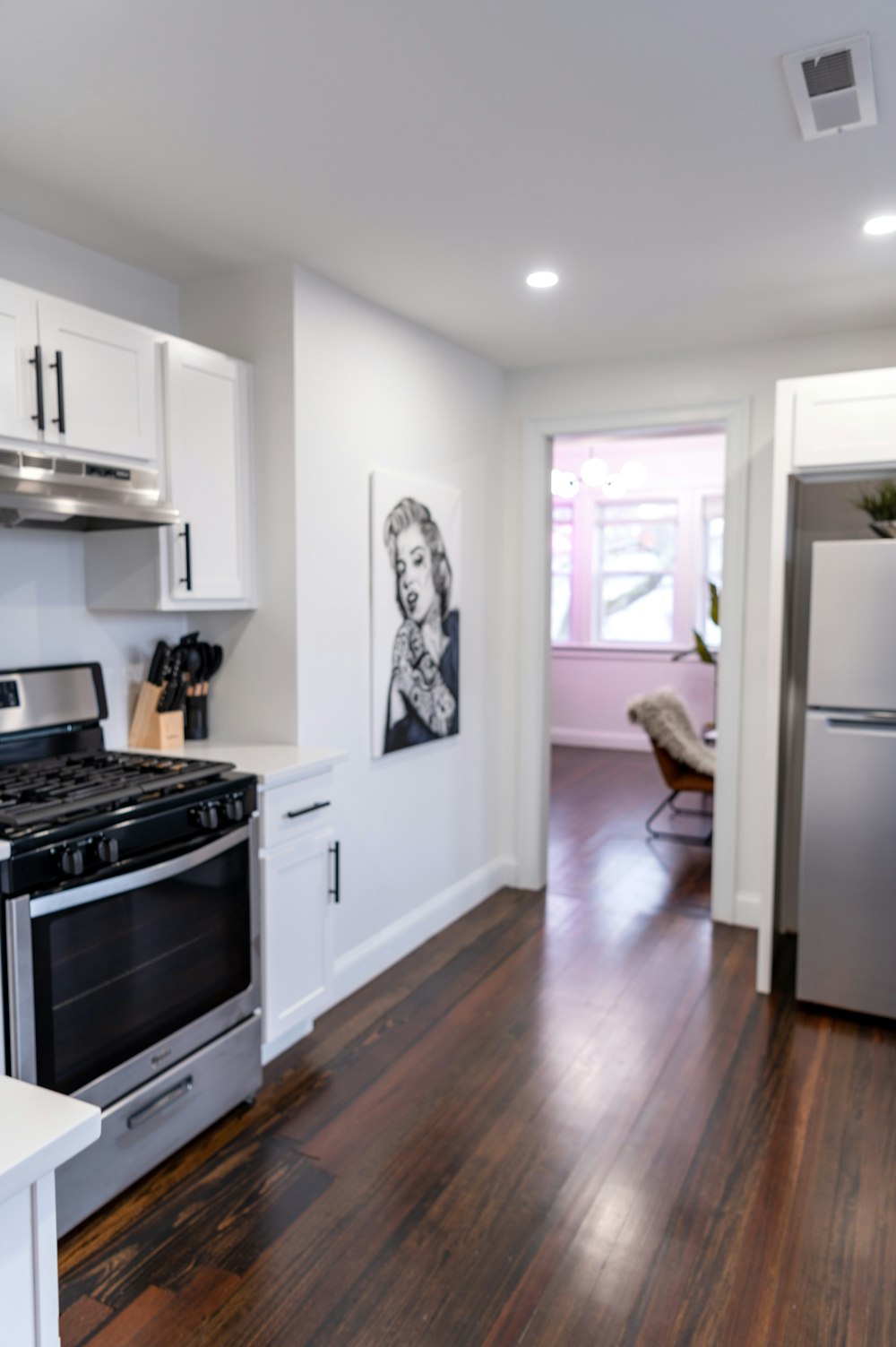 white top mount refrigerator beside white wooden kitchen cabinet