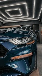 Close-up of a sleek, charcoal epoxy garage floor with subtle teal accents reflecting natural light.