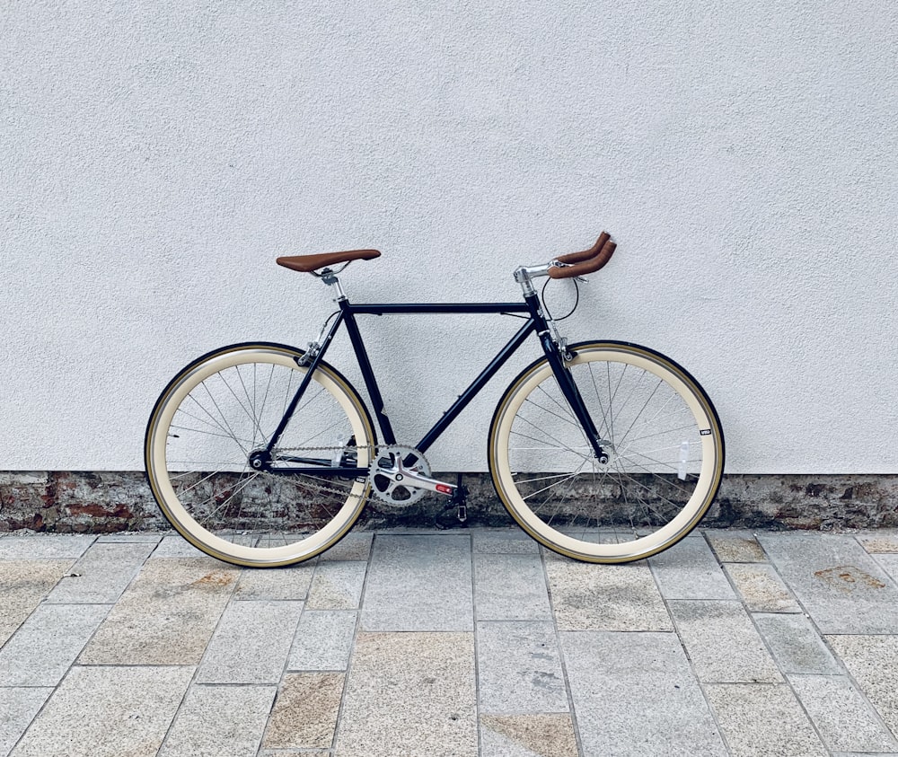 Bicicleta de carretera marrón y blanco sobre suelo de hormigón gris