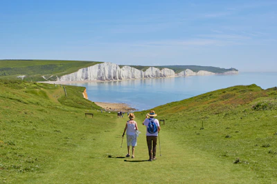 2 men standing on green grass field near body of water during daytime