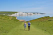 2 men standing on green grass field near body of water during daytime