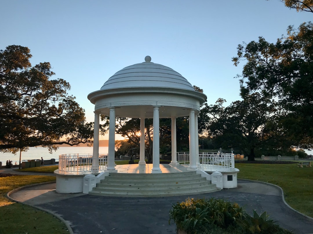 white gazebo near green trees during daytime