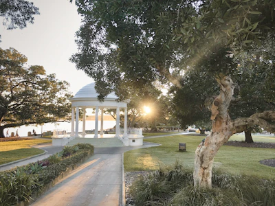 white gazebo surrounded by green trees during daytime