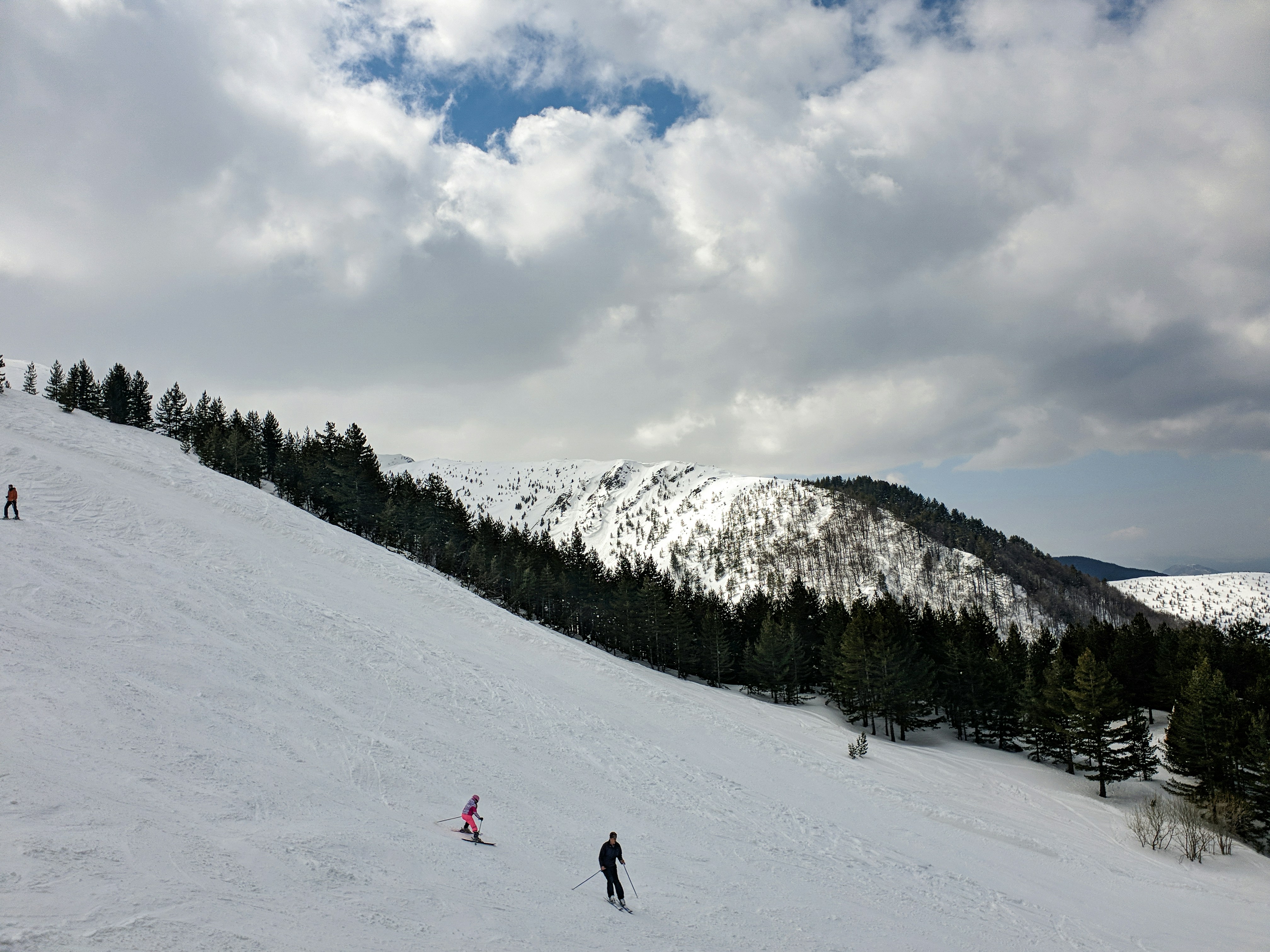 person in black jacket and black pants walking on snow covered ground during daytime