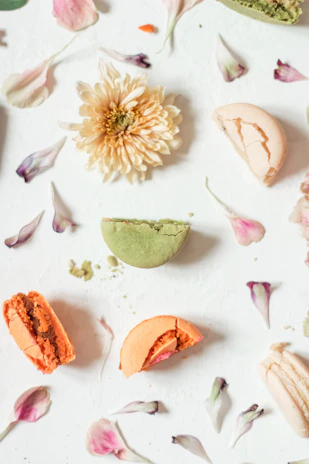 Elegant flat lay of the éclat rose dress on a cream background with delicate rose petals scattered around.