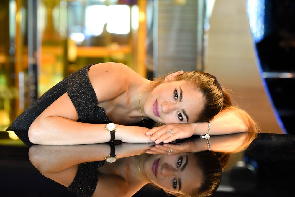 woman in black tank top lying on floor