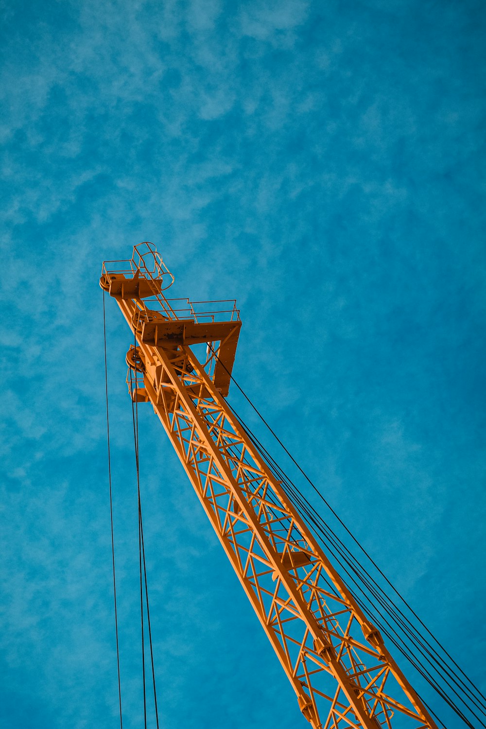 orange metal crane under blue sky