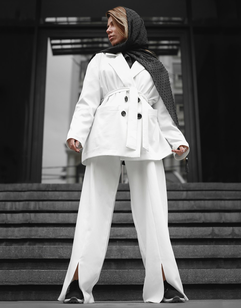 woman in white coat and pants standing on stairs