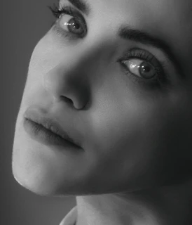 Close-up of a poised professional woman with subtle lighting highlighting her determined expression.