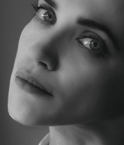 Close-up of a poised professional woman with subtle lighting highlighting her determined expression.