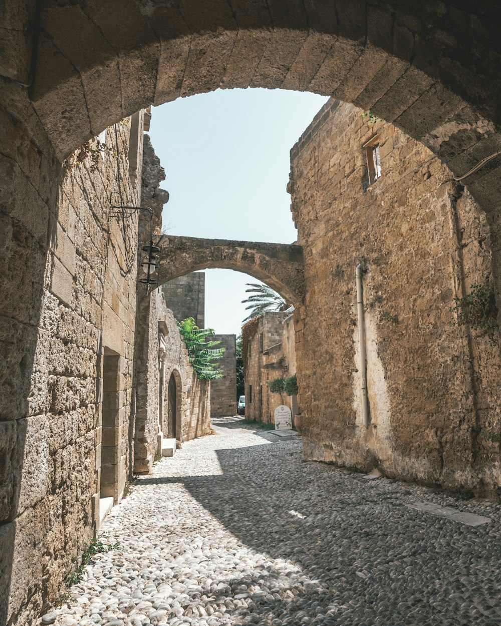 brown brick arch hallway during daytime