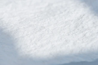 Close-up of a hand wiping a surface with a soft, white disposable cotton towel.