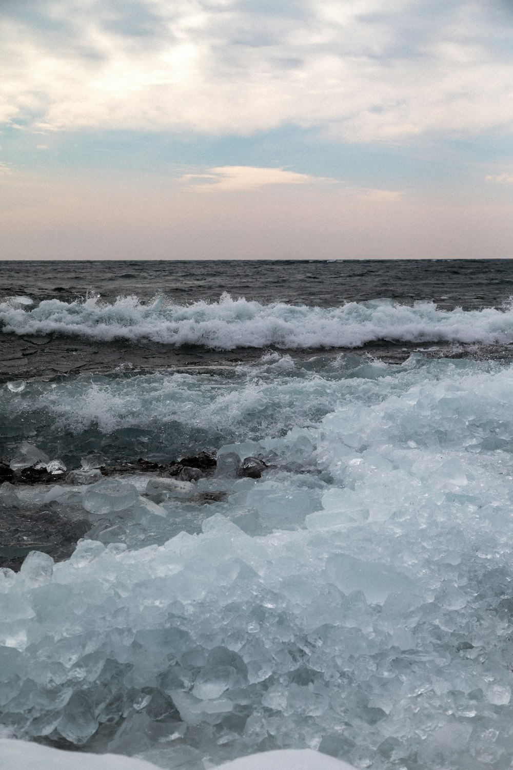 ocean waves crashing on shore during sunset