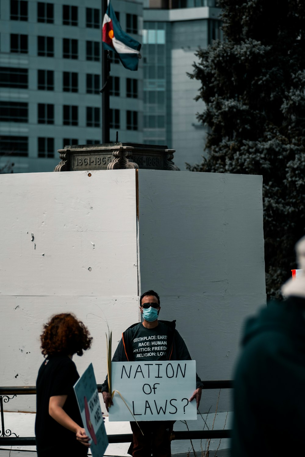 persone in piedi vicino a un edificio in cemento bianco durante il giorno