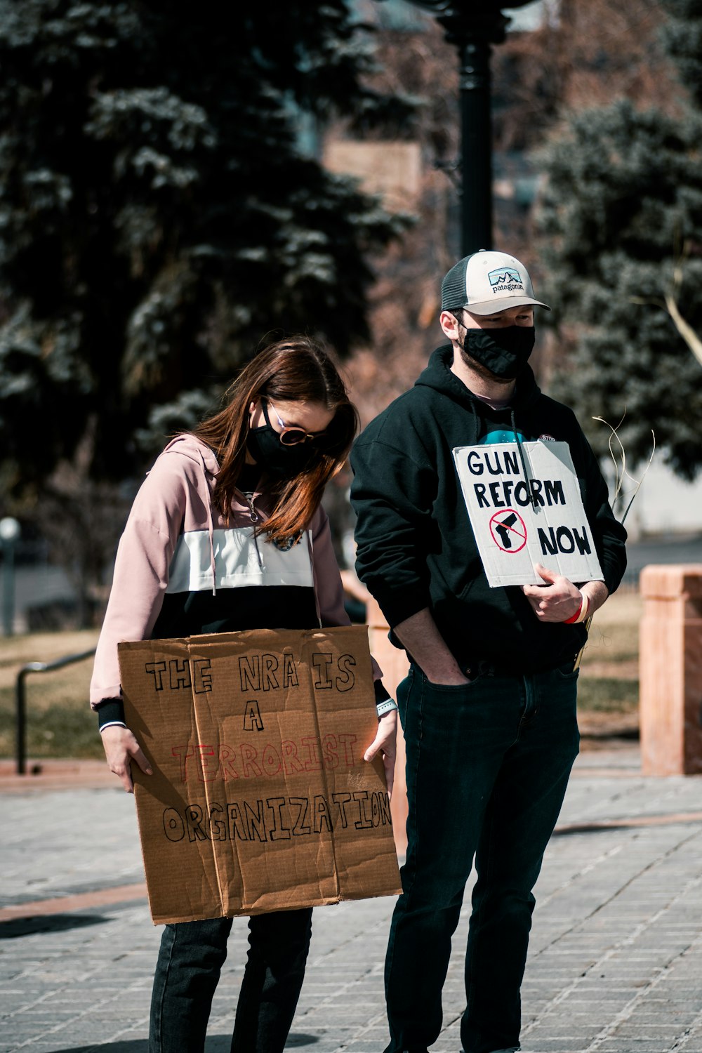 woman in black and white long sleeve shirt holding brown cardboard box