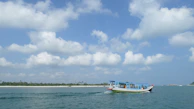 A traditional wooden boat sailing from Punta Cana toward Saona Island with blue skies above.