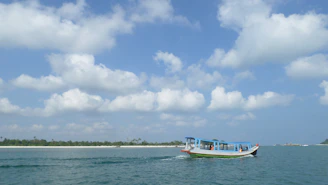 A traditional wooden boat sailing from Punta Cana toward Saona Island with blue skies above.