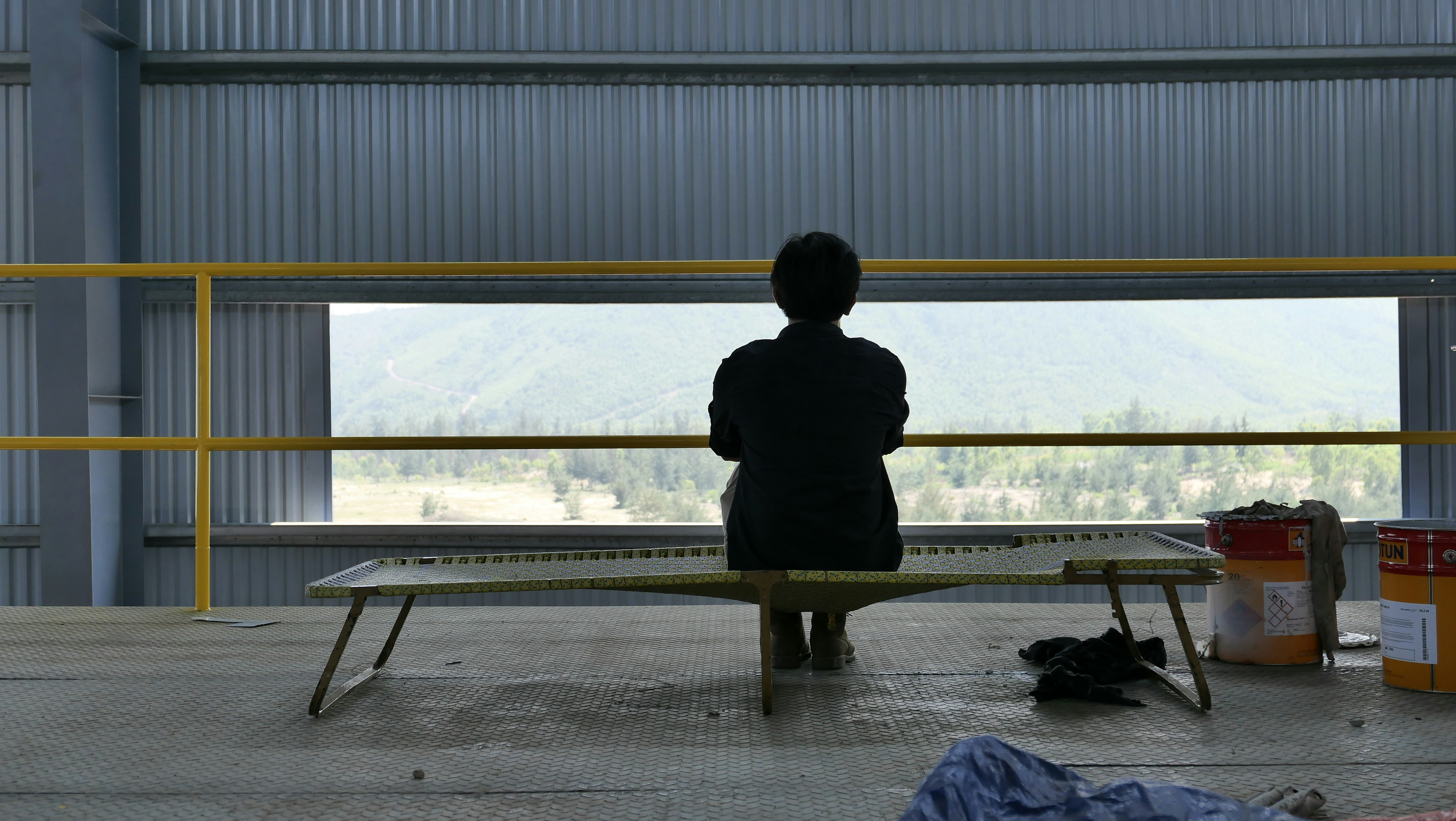 person in black coat sitting on bench