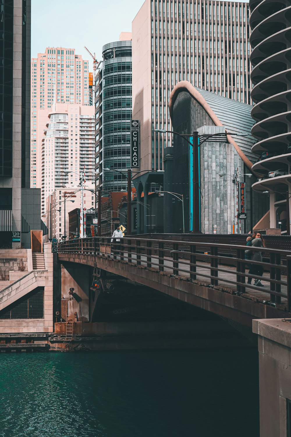 people walking on bridge near high rise buildings during daytime