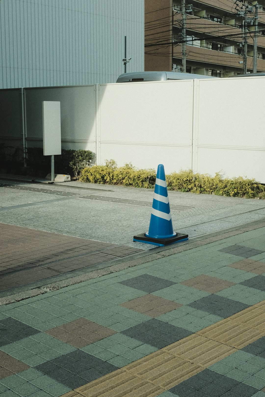 blue and white striped traffic cone on gray concrete road