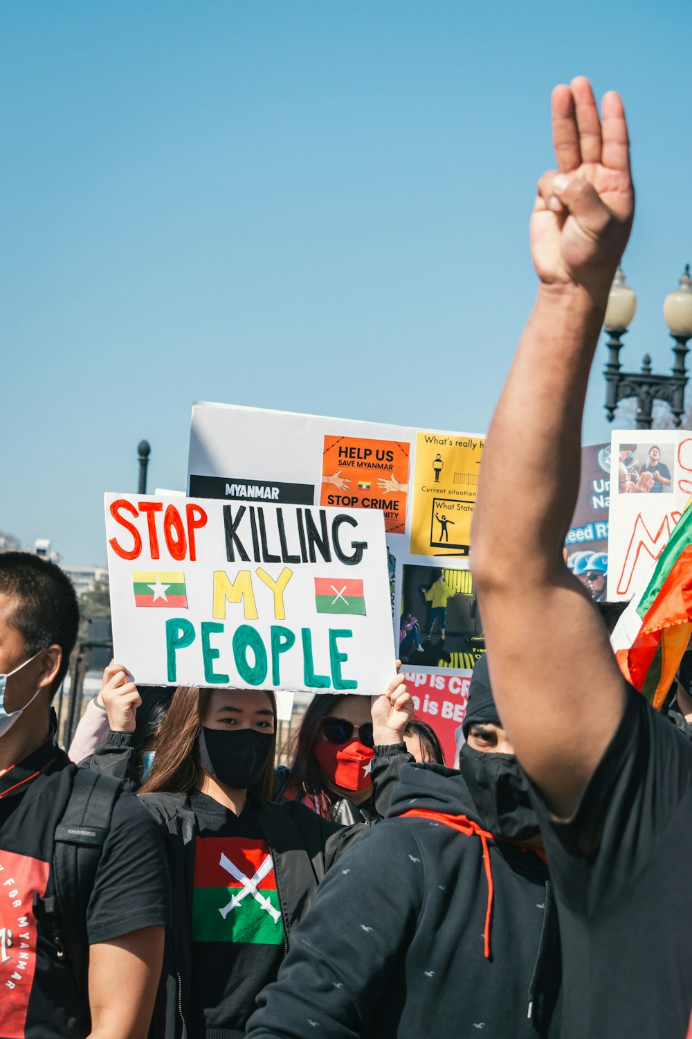 man in black polo shirt holding white and yellow signage during daytime