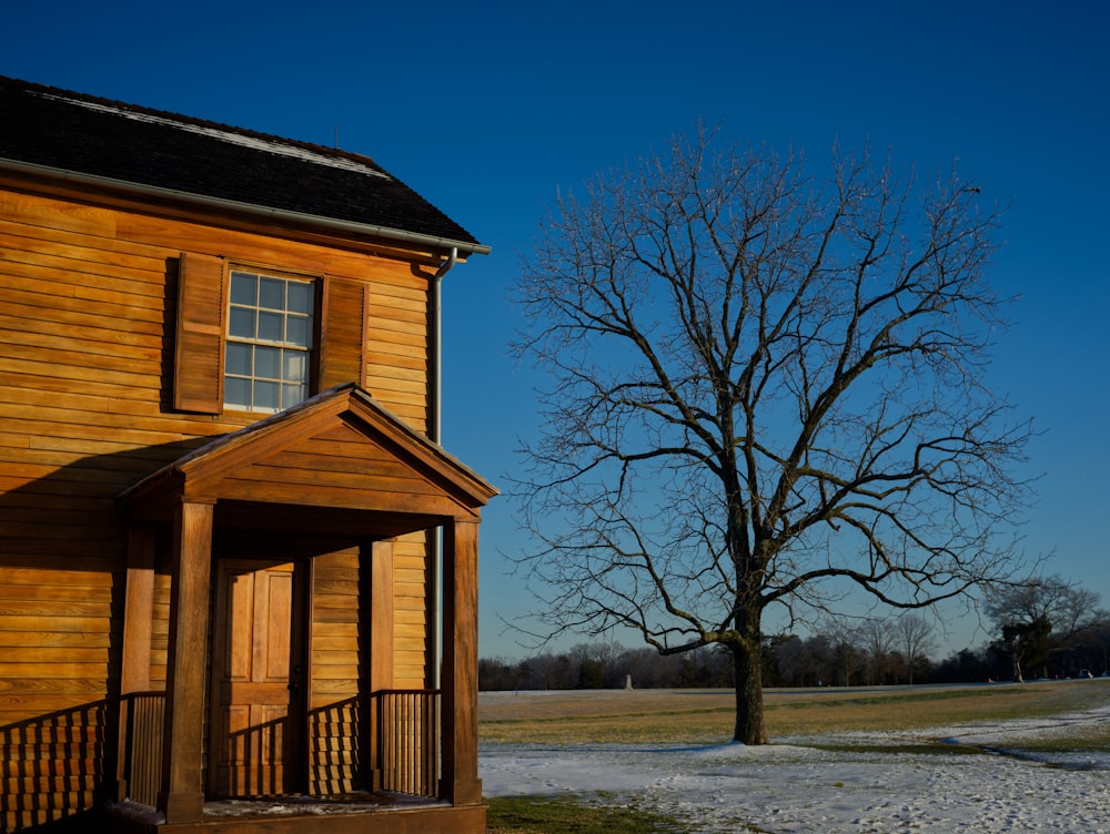 brown wooden house near bare trees during daytime