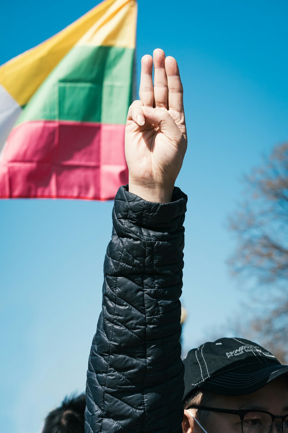 person in black leather jacket holding red yellow and green flag