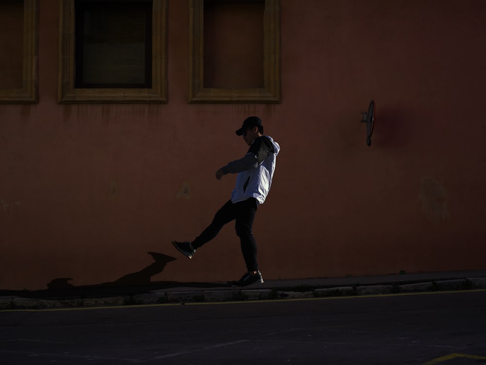 man in white shirt and black pants jumping on black skateboard