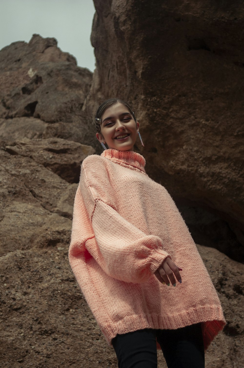 woman in pink and white stripe robe standing on brown rock