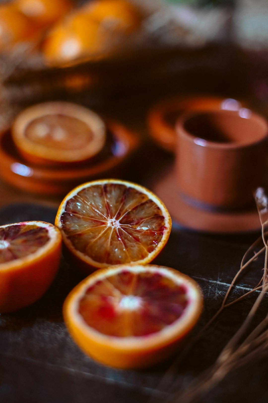 sliced orange fruit beside brown ceramic mug