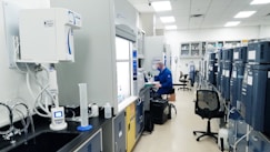 man in blue scrub suit standing near white and black office rolling chair