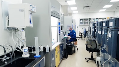 man in blue scrub suit standing near white and black office rolling chair