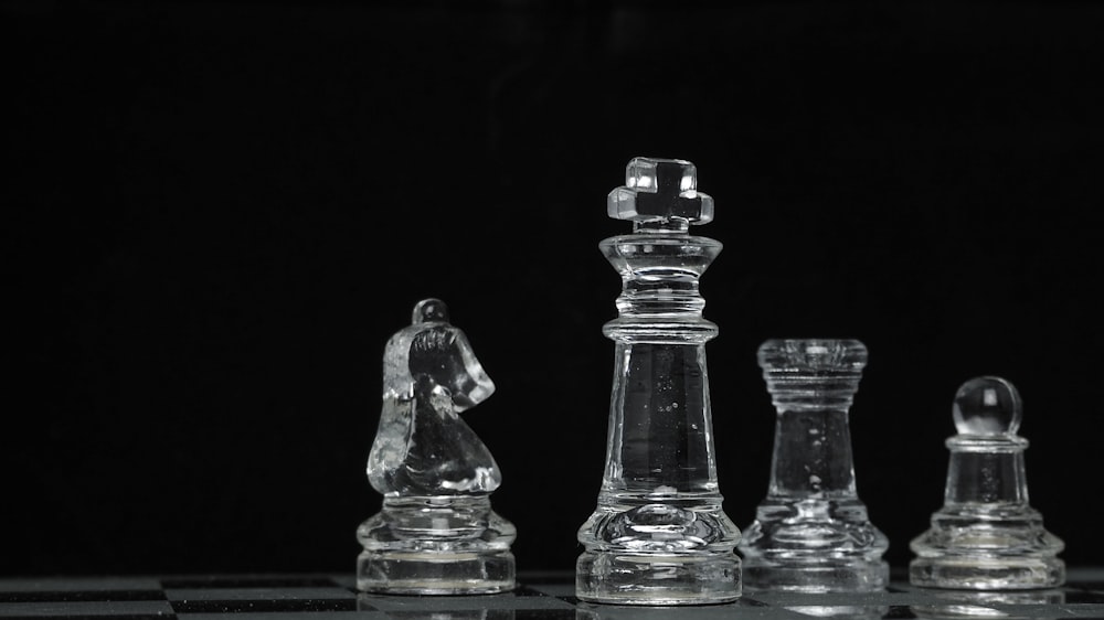 Pièce d’échecs en verre transparent sur surface noire